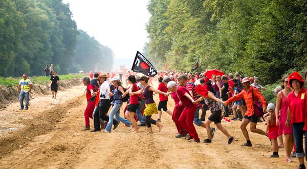 Demonstranten in rot bilden am Hambacher Forst eine Linie