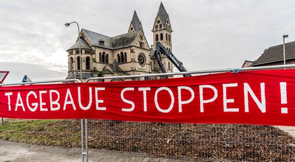 Immerather Dom hinter Absperrgitter mit Banner "Tagebaue stoppen"