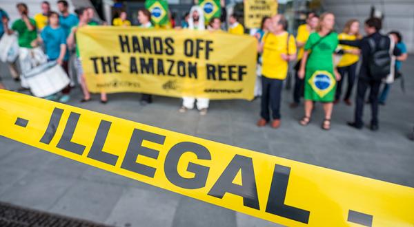 Greenpeace-Aktivisten protestieren in Paris gegen Öl, Absperrband mit Aufschrift "Illegal"