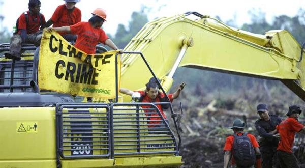 Greenpeace-Aktivisten protestieren an einem Bagger der Fa. APRIL gegen Regenwaldzerstörung in Indonesien, 12. November 2009