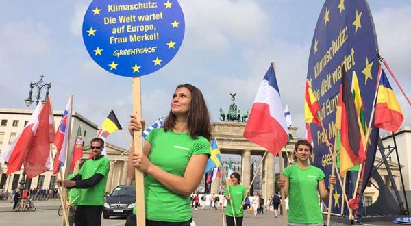 „Klimaschutz: Die Welt wartet auf Europa, Frau Merkel!“ steht auf einer fünf Meter großen Scheibe, die Greenpeace-Aktivisten anlässlich des Petersberger Dialogs vor dem Brandenburger Tor aufgestellt haben. Juli 2014