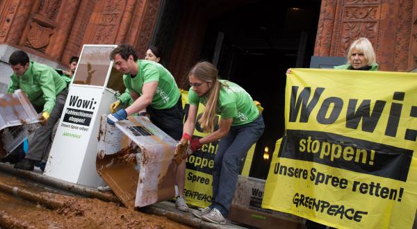 Greenpeace-Aktivisten kippen zum Protest gegen Kohleabbau Spree-Schlamm vors Berliner Rathaus.