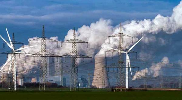 Braunkohlekraftwerk Neurath bei Grevenbroich - Dampf steigt aus Kühltürmen auf, im Vordergrund Windräder.