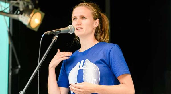 Marion Tiemann von Greenpeace spricht bei der Fahrradsternfahrt in Köln. Die Lunge auf ihrem T-Shirt symbolisiert die Gefahr durch Dieselfahrzeuge, die gesundheitsschädliche Stickoxide ausstoßen.