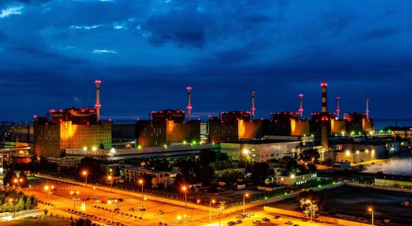 Kraftwerksblöcke und das Gelände des Atomkraftwerks Saporischschja sind nachts beleuchtet