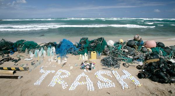 Aus Plastikmüll gelegter Schriftzug "Trash" am Strand von Hawaii