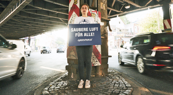 Greenpeace-Aktivistin mit einem Schild "Saubere Luft für alle an der Stresemannstraße in Hamburg. Dort ist das Diesel-Fahrverbot ab heute inkraft.