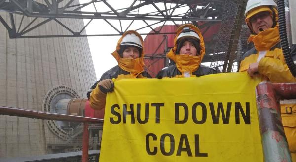 Aktivisten mit Banner vor Kohlekraftwerk Neurath