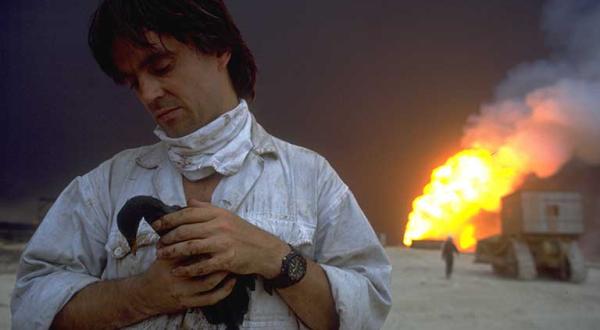 Brennende Ölfelder: Greenpeace Kampaigner Paul Horsman in Kuwait mit einem veröltem Vogel, September 1991