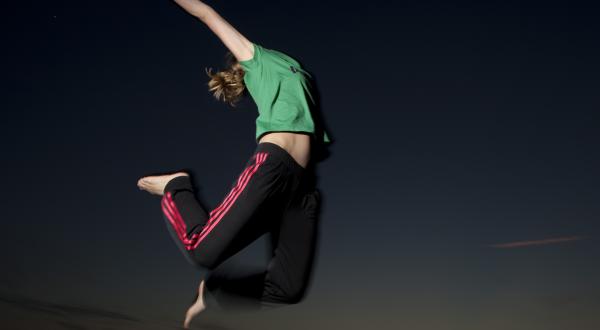 Model in Adidas-Hose und Puma-Shirt springt in die Luft