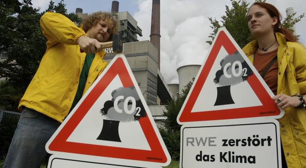 Greenpeace-Aktivisten protestieren mit Warmschildern gegen die Grundsteinlegung für ein Braunkohlekraftwerk in Neurath, August 2006