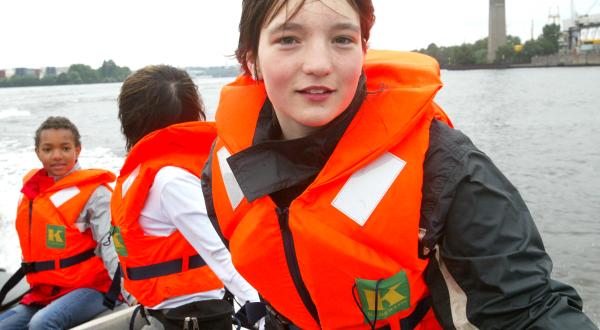 Kinder feiern im Greenpeace Lager am Rethedamm ein Kinderfest. Kinder mit Schwimmwesten fahren Schlauchboot.