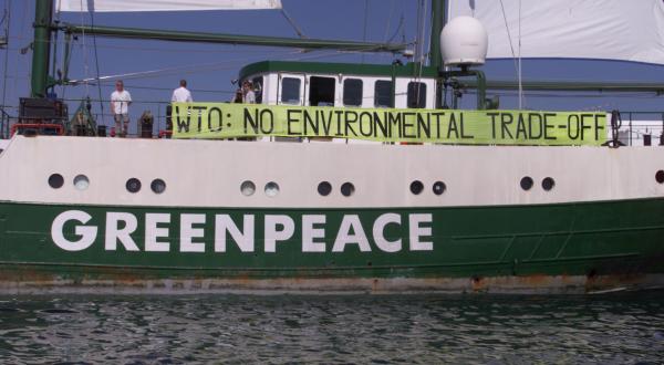 Protest gegen die WTO mit der Rainbow Warrior, an der ein Banner befestigt ist: "WTO: no environmental trade-off" . Qatar, im Jahr 2001.