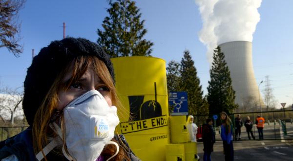 5. März 2014: Greenpeace-Aktivisten protestieren am belgischen Atomkraftwerk Tihange (Belgien) gegen ueberalterte Atomkraftwerke. Aktivisten protestieren mit Atomfässern und Absperrband, Aufschrift: "The End" ("Das Ende").