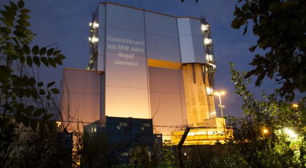 Greenpeace-Aktivisten projizieren "Atommüllexport aus AKW Jülich illegal " auf das Gebäude des AKW Jülich