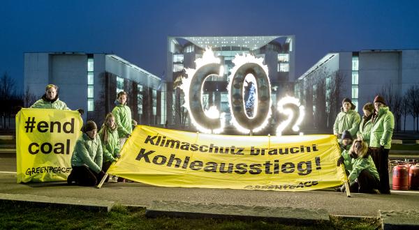 Greenpeace-Aktivisten mit Bannern und brennendem CO2-Schriftzug vor dem Kanzleramt