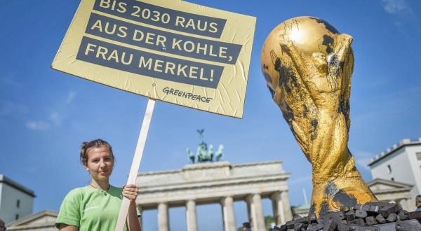Greenpeace-Aktivistin fordert mit verschmutzem WM-Pokal Merkel zum Kohleausstieg auf
