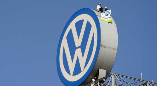 Greenpeace-Aktivisten mit Banner auf dem Logo von VW in Wolfsburg im April 2012.