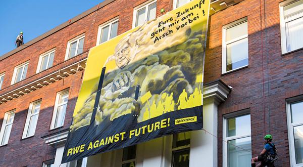 Banner mit Kohlekraftwerken und RWE Boss Schmitz und den Worten "Eure Zukunft geht mir am Arsch vorbei"