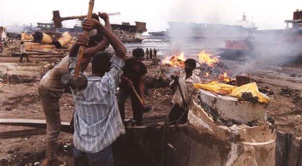 Arbeiter zerschlagen mit Hämmern eine Schiffsschraube am Strand der Bucht von Alang / Indien, September 1998