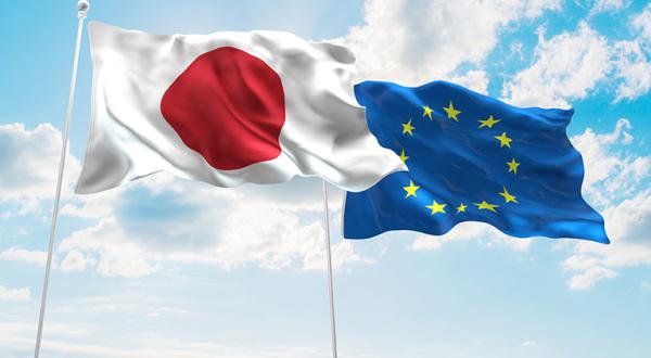Zwei Flaggen, Japan und EU, vor blauem Himmel