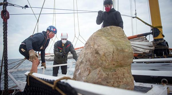 Greenpeace Aktivistinnen und Aktivisten versenken Granitgestein von Bord der „Beluga II“.