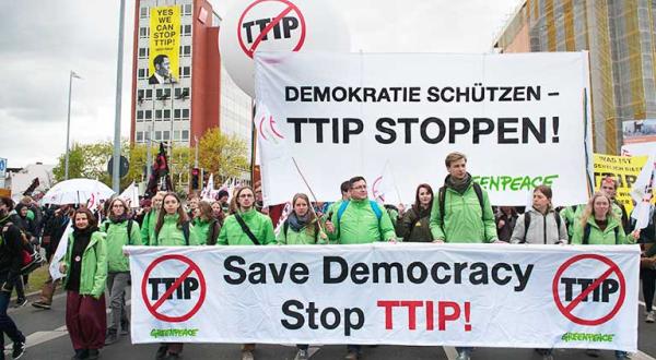 Greenpeace-Aktivisten auf der Anti-TTIP-Demo in Hannover. Sie halten ein Banner mit der Aufschrift "Save Democracy - Stop TTIP".