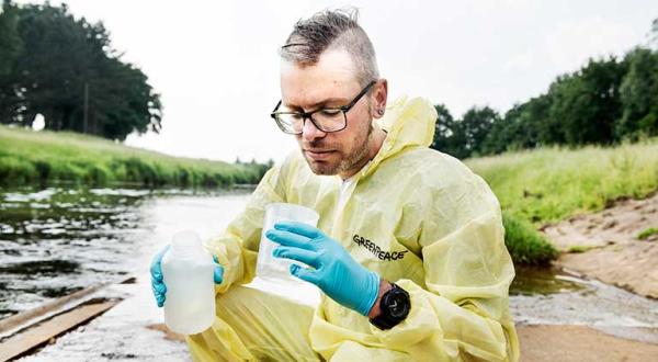 Dirk Zimmermann, Experte für Landwirtschaft bei Greenpeace, nimmt Wasserproben aus dem Fluss Hase im Landkreis Oldenburg