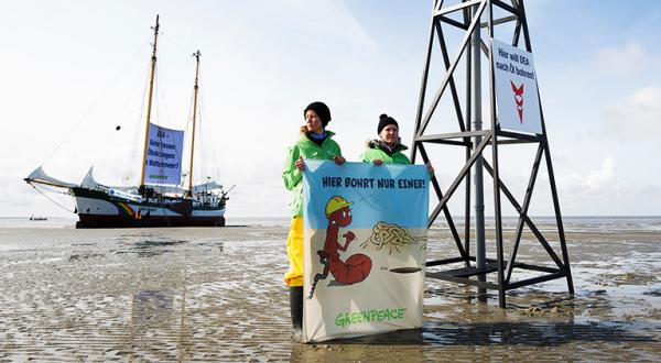 Greenpeace-Aktivisten mit Banner "Hier bohrt nur einer"