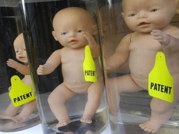 Greenpeace-Aktivisten demonstrieren vor dem Bundesjustizministerium gegen Patent auf das Klonen menschlicher Embryonen. Vor dem Eingang haben sie ein etwa vier Meter hohes Regal mit 20 großen Reagenzgläsern mit Baby-Puppen errichtet.