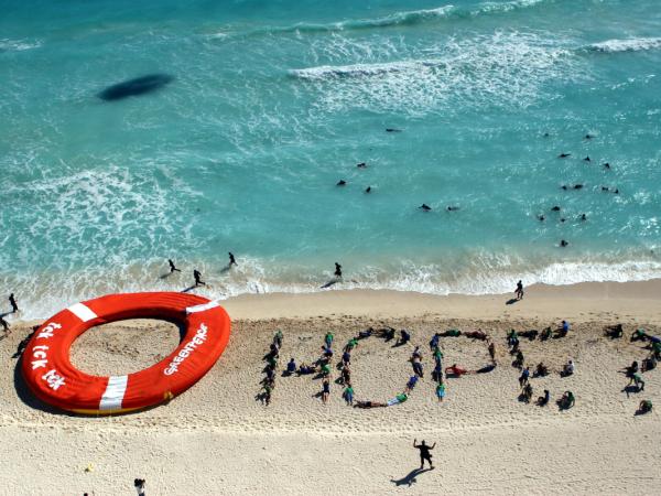 Während die Klimaverhandlungen auf der COP16-Konferenz der Vereinten Nationen in den letzten Tag gehen, formen Greenpeace- und TckTckTck-Aktivist:innen das Wort "Hope?" (Hoffnung) und legen einen riesigen Rettungsring an den Strand von Cancún, um den Teilnehmer:innen, die mit den Verhandlungen kämpfen, einen symbolischen Rettungsring zuzuwerfen. 