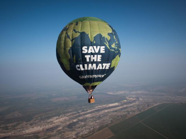 Ein Heißluftballon überfliegt den Braunkohletagebau Profen in der Nähe des ältesten deutschen Braunkohlekraftwerks Deuben aus dem Jahr 1936 und protestiert gegen dessen klimaschädliche Emissionen.