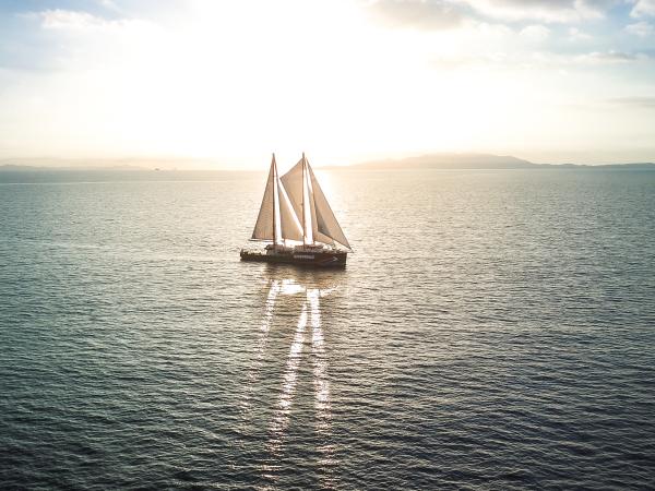 Das Greenpeace-Schiff "Rainbow Warrior" auf offener See im Sonnenlicht.