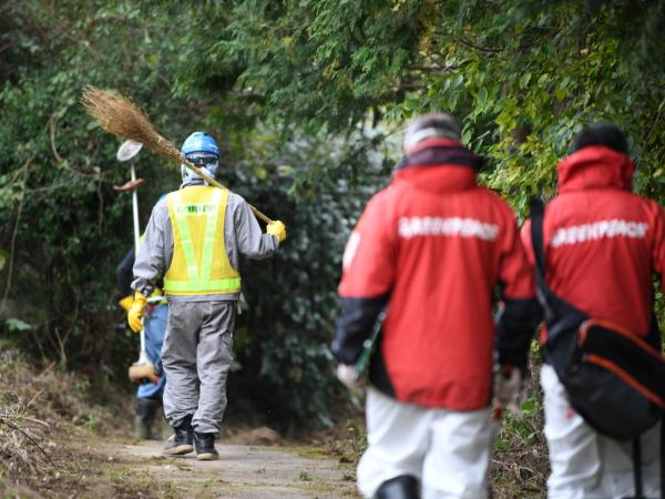 Arbeiter und Greenpeace-Strahlenspezialisten in Namie, Präfektur Fukushima