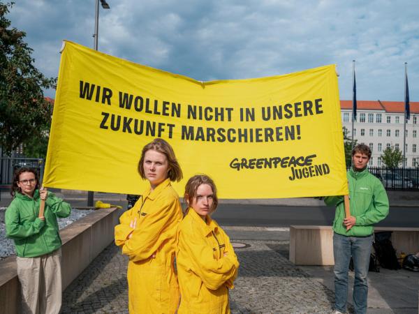 Zwei Greenpeace-Jugendliche protestieren mit einem Banner "wir wollen nicht in die Zukunft marschieren" gegen drohende Wehrpflicht