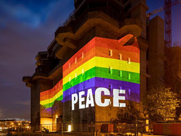 Aktivist:innen projizieren das Wort "Frieden" und einen Regenbogen auf die Wände des denkmalgeschützten Flakbunkers IV in Hamburg. 