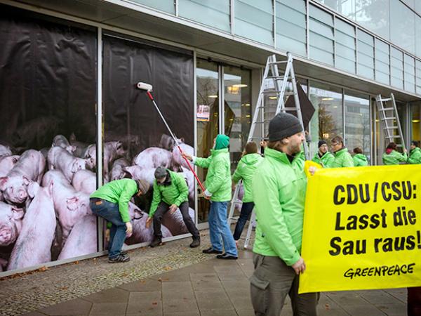 Aktivisten bekleben in Berlin die CDU-Parteizentrale mit Fotofolien mit Schweinestall-Motiv